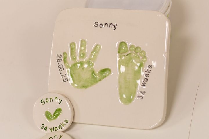 Clay impressions of babys hands and feet in clay