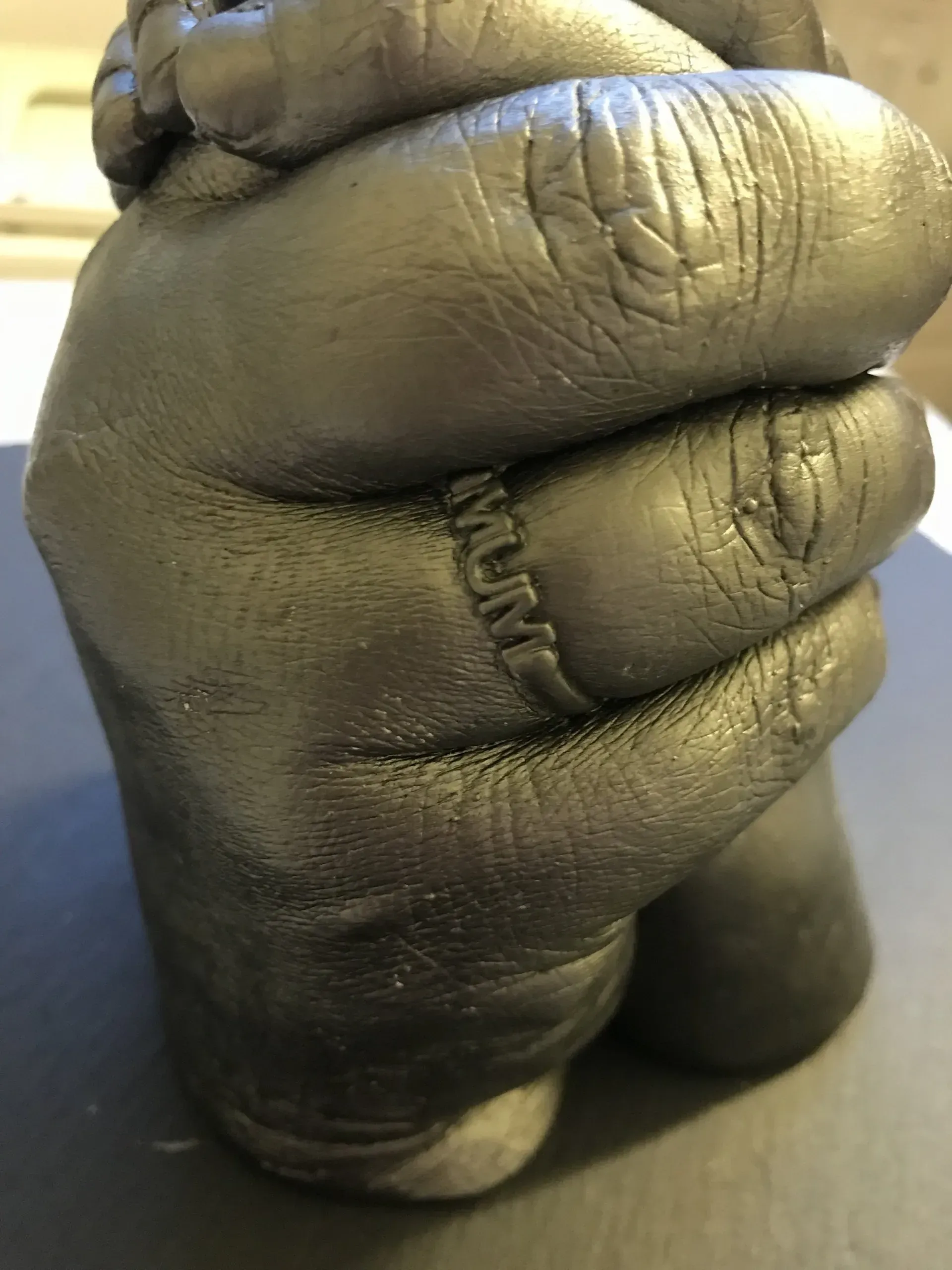 A close up of a hand cast with a ring on it.