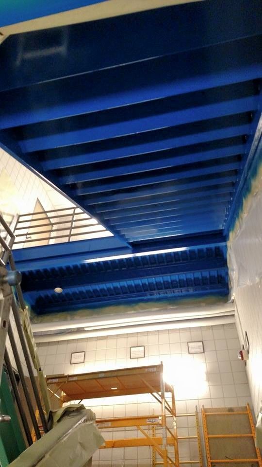 Blue ceiling with metal beams; workshop interior.