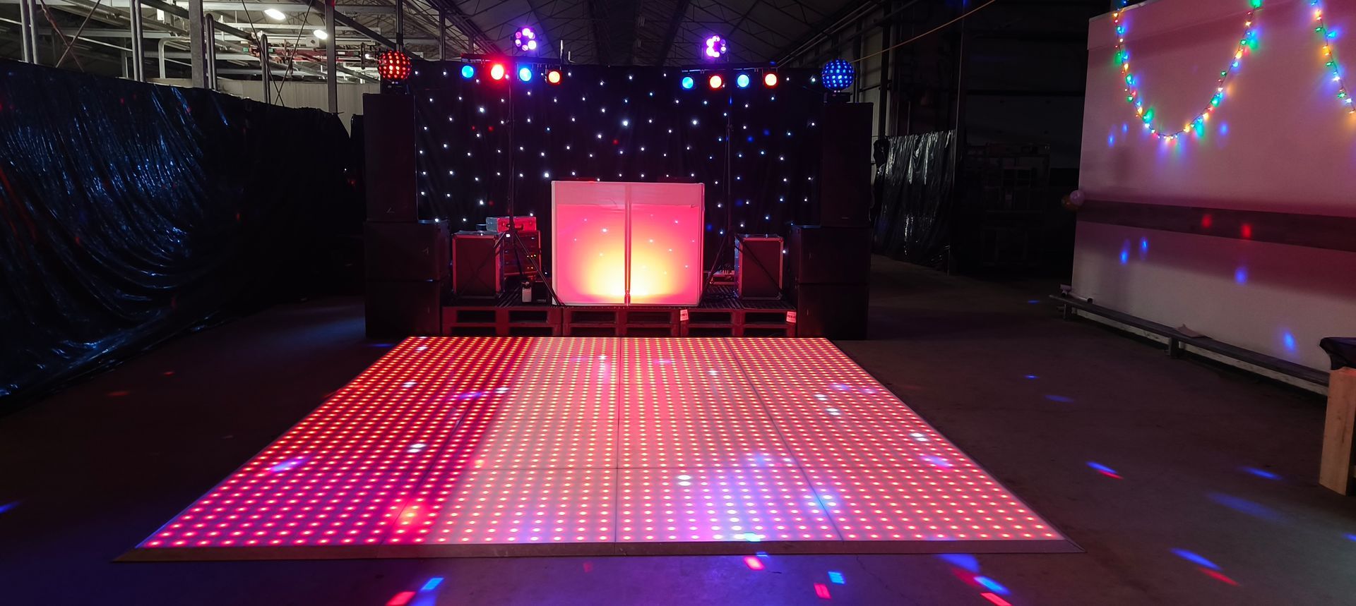 Discoshow met verlichte dansvloer en sterrenachterwand