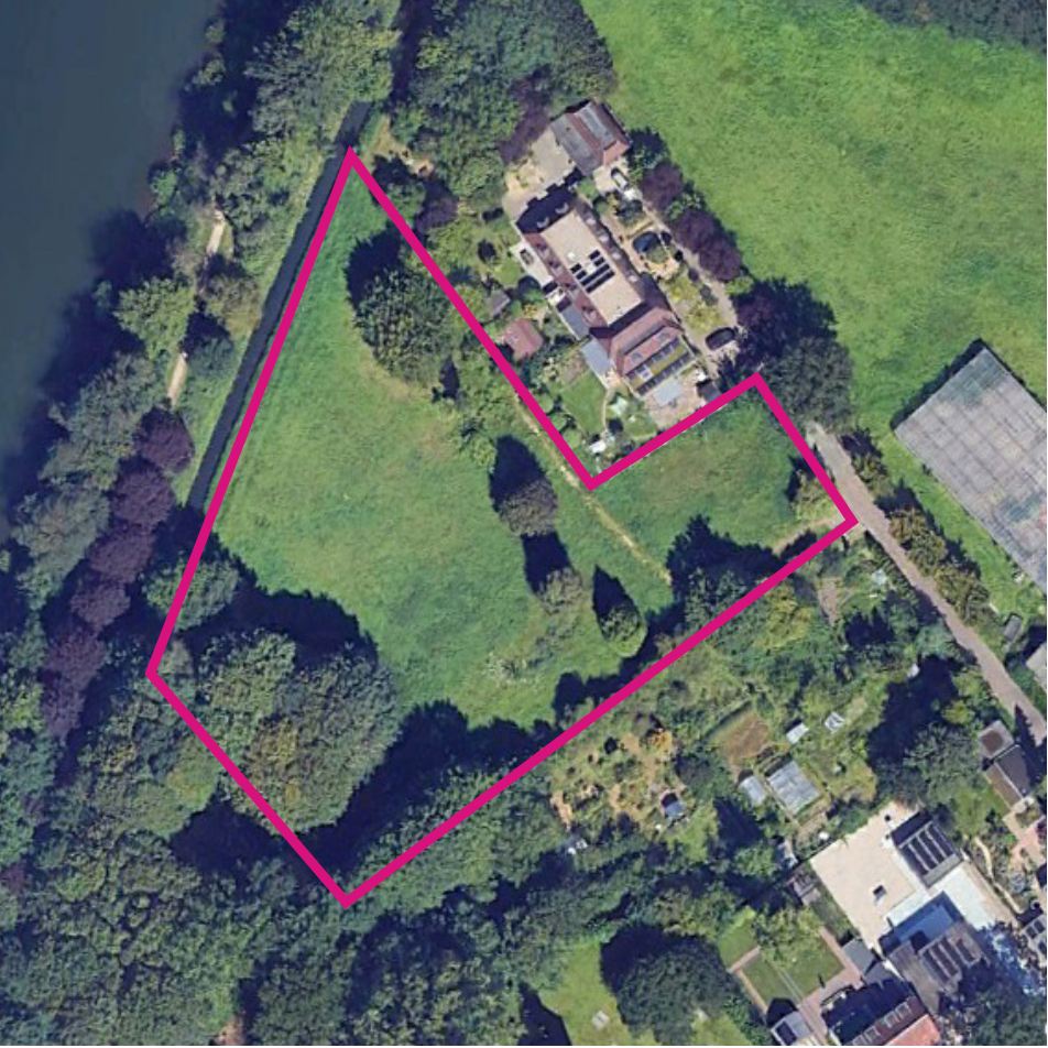 Luchtfoto van een grasveld met bomen, omlijnd in roze, naast een kanaal en huizen.