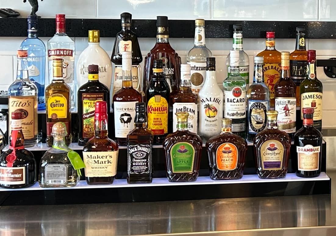 A bar with a lot of bottles of liquor on it