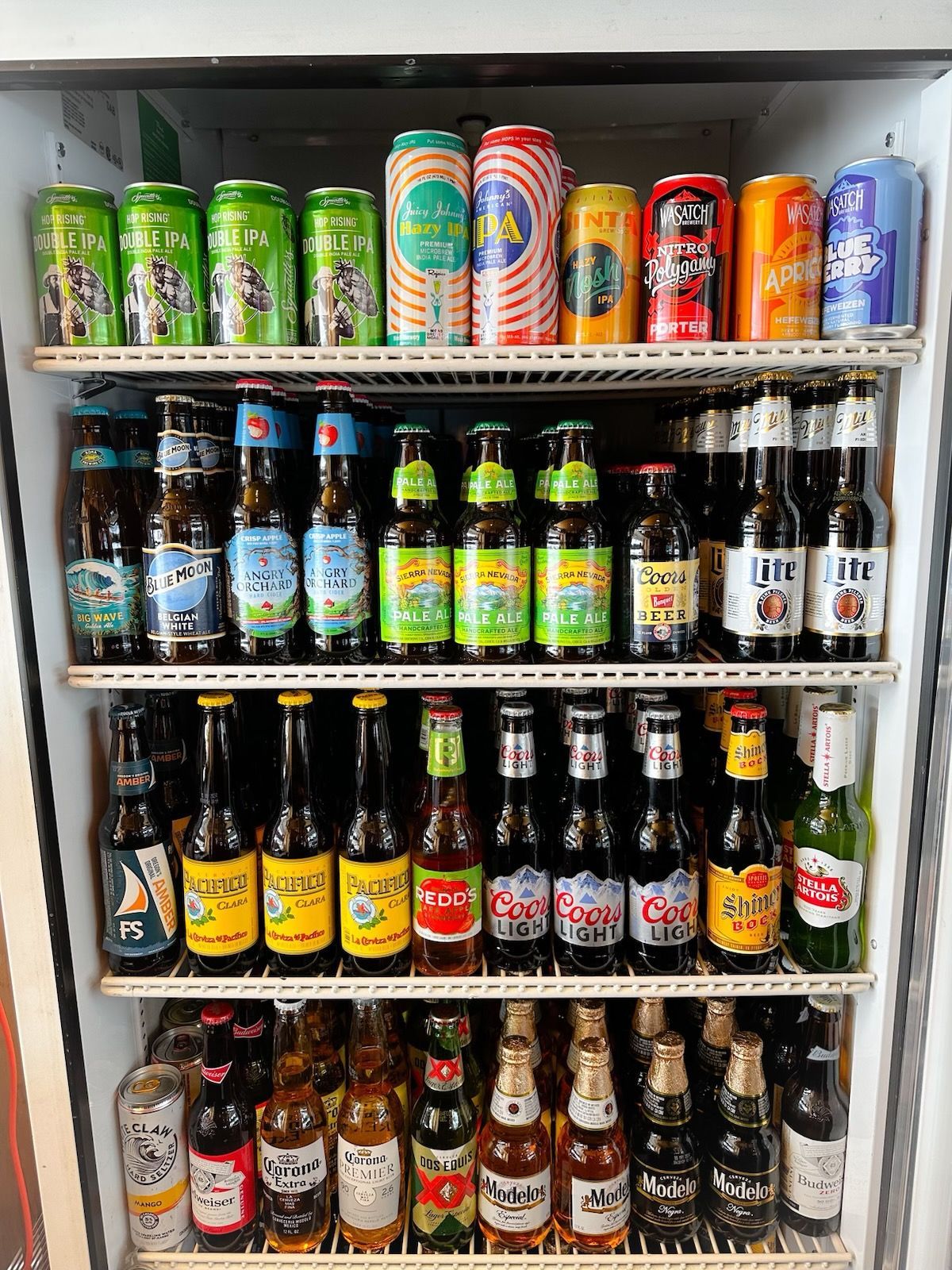 A refrigerator filled with bottles and cans of beer.