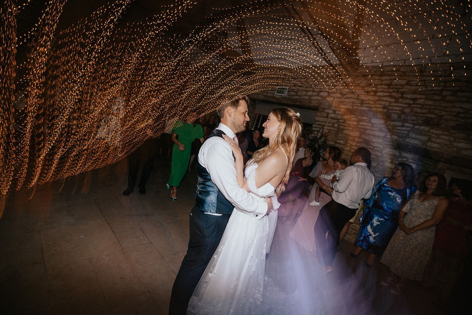 A bride and groom are dancing their first dance at their wedding reception.