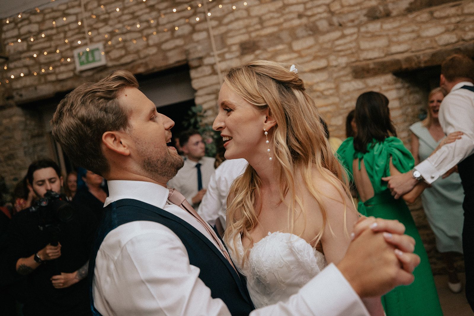 A bride and groom are dancing together at their wedding reception.
