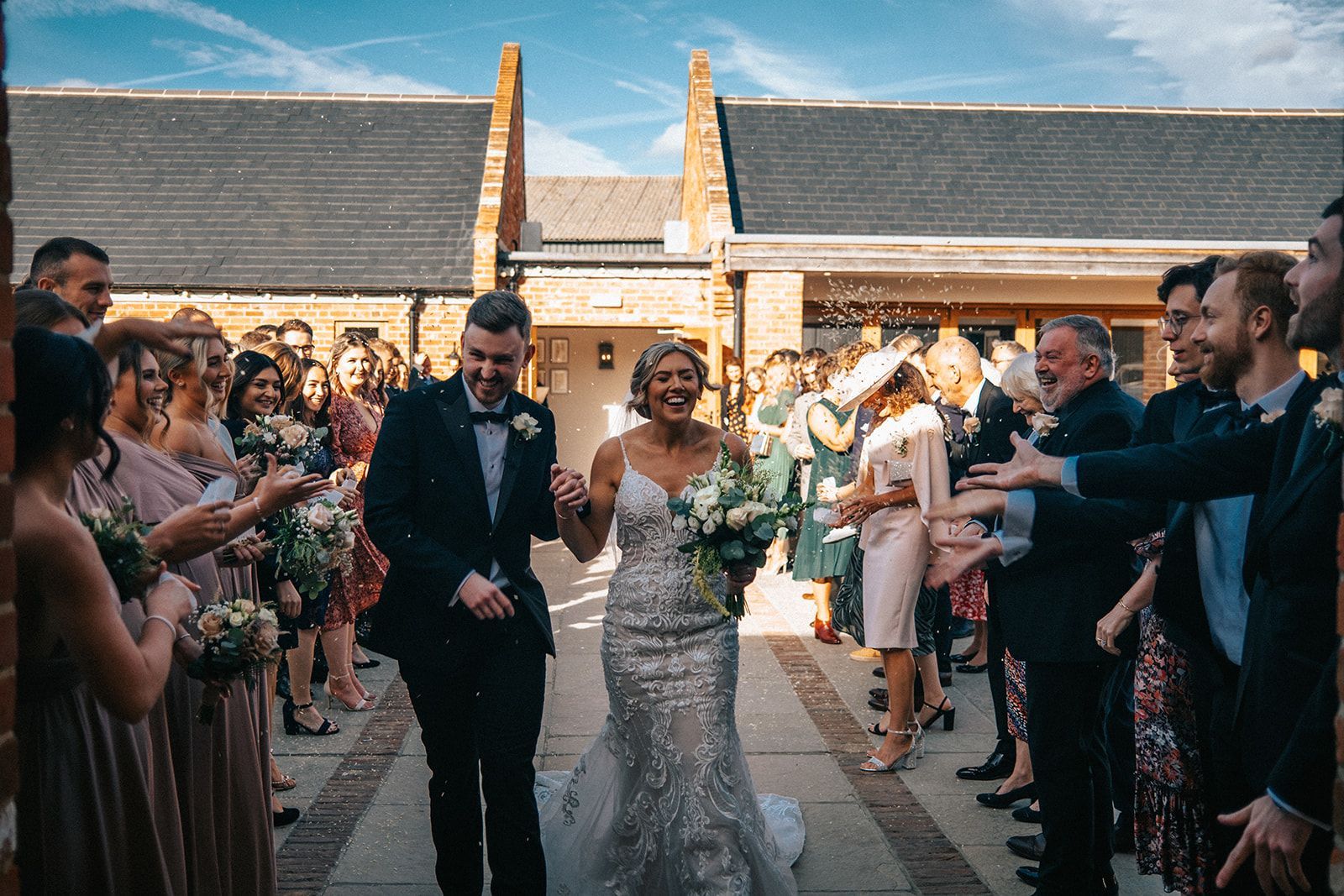 A bride and groom are walking down the aisle surrounded by their wedding party.