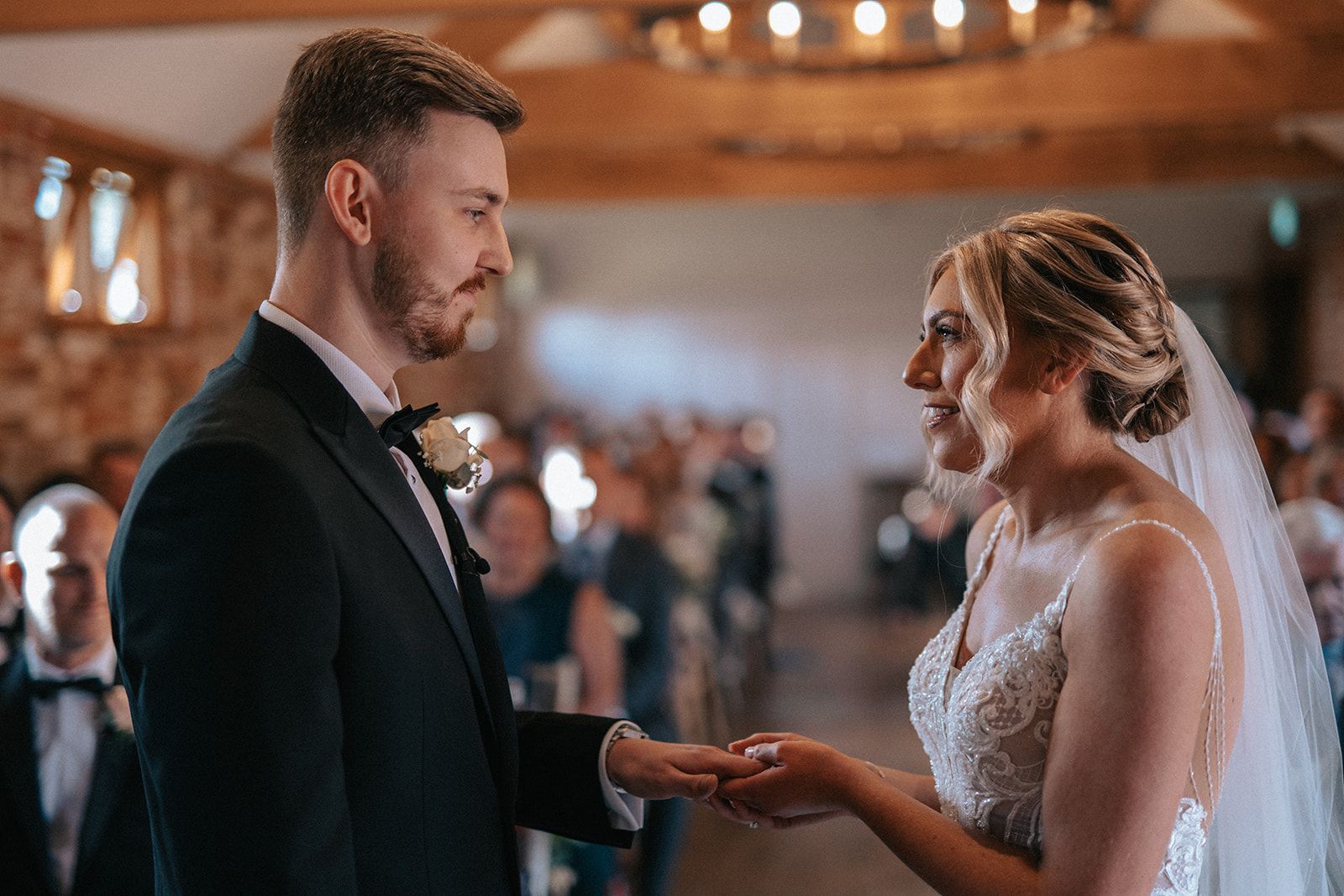 A bride and groom are holding hands during their wedding ceremony.
