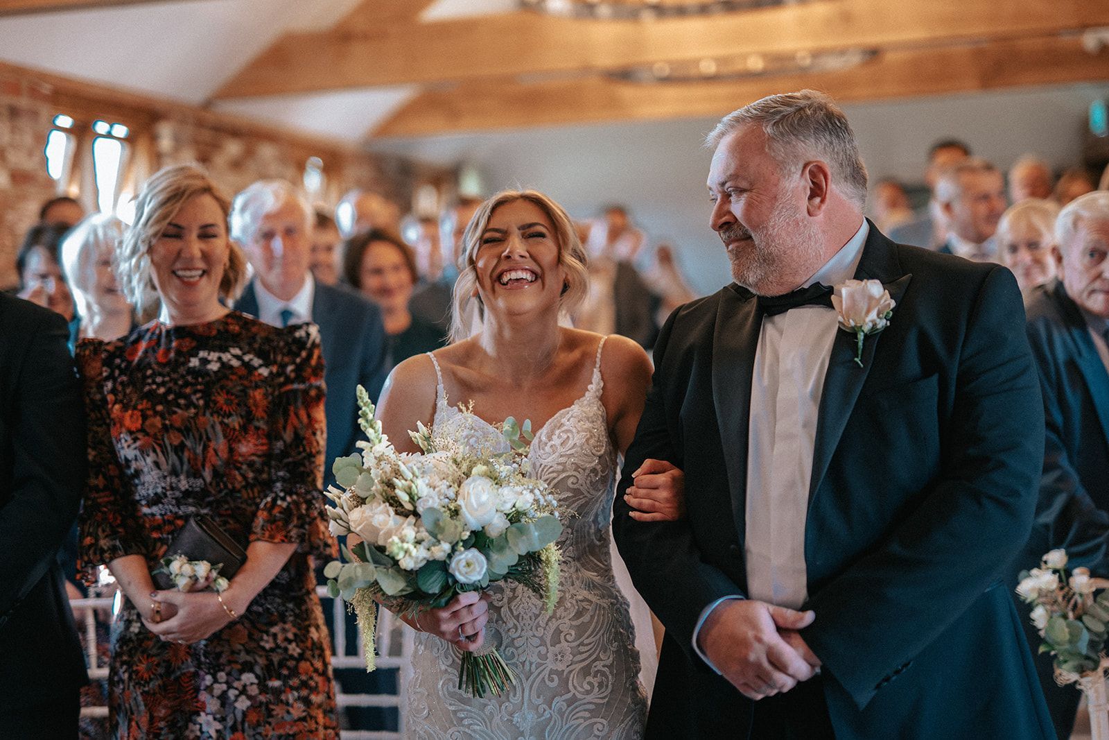 A bride is walking down the aisle with her father.