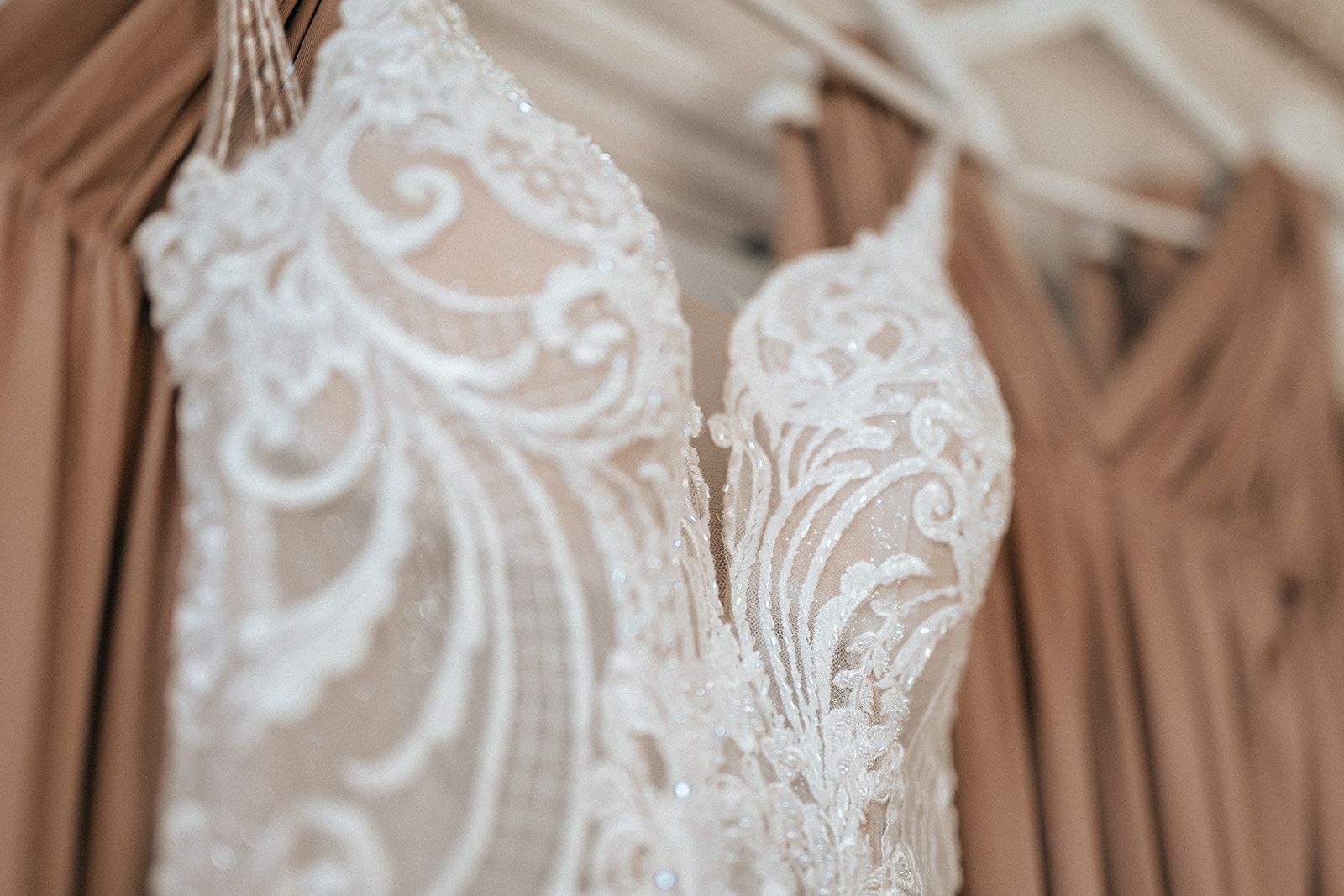 A close up of a wedding dress hanging on a hanger.