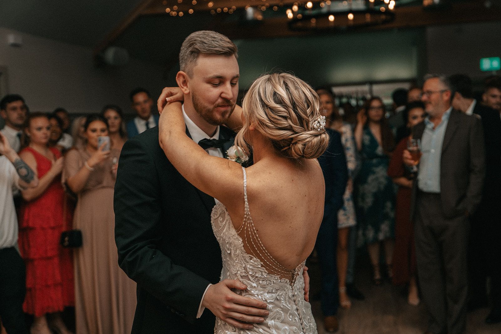 A bride and groom are dancing their first dance at their wedding reception.