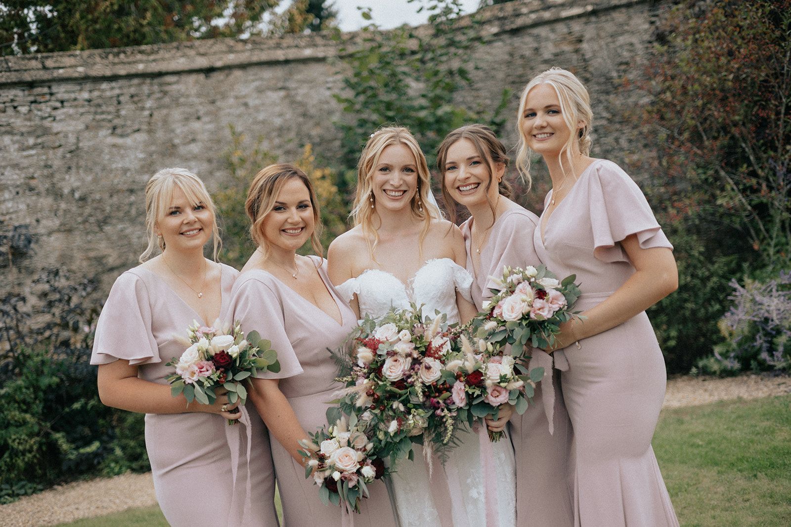 A bride and her bridesmaids are posing for a picture.