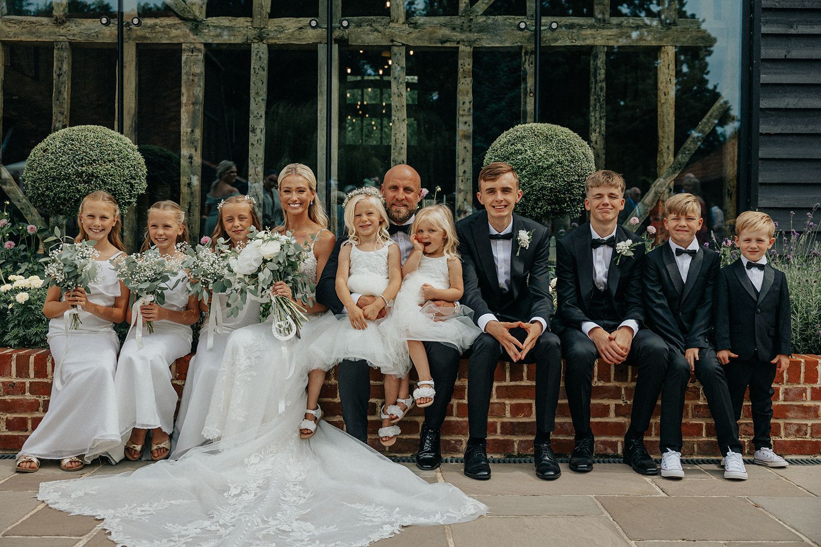 A bride and groom are posing for a picture with their wedding party.