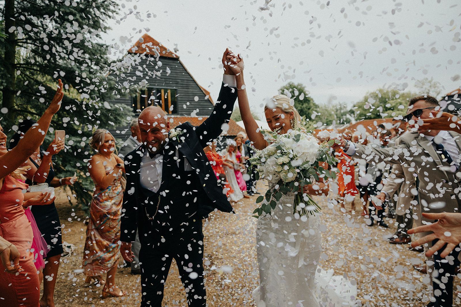 A bride and groom are being showered with confetti at their wedding reception.