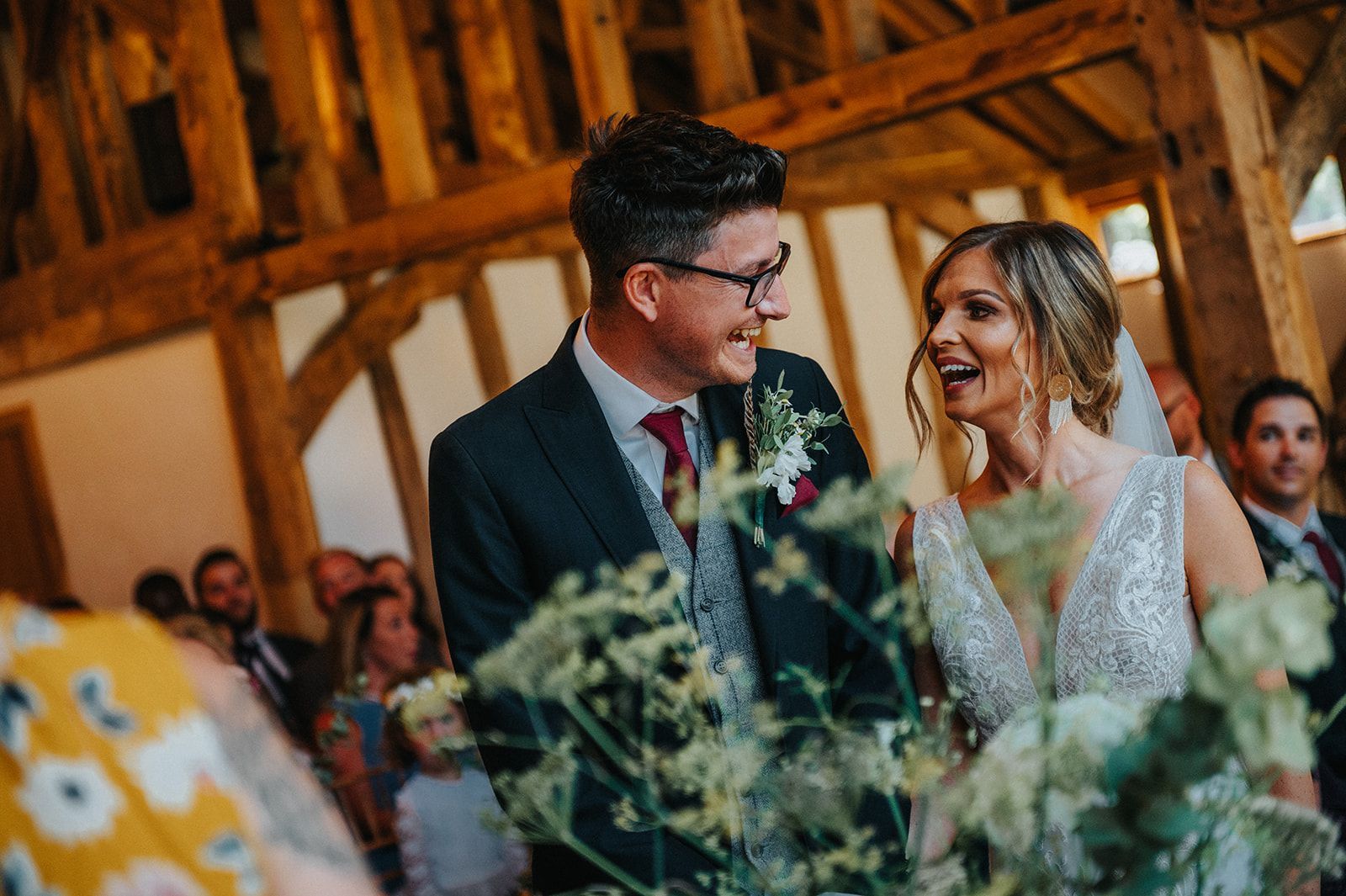 A bride and groom are laughing during their wedding ceremony.
