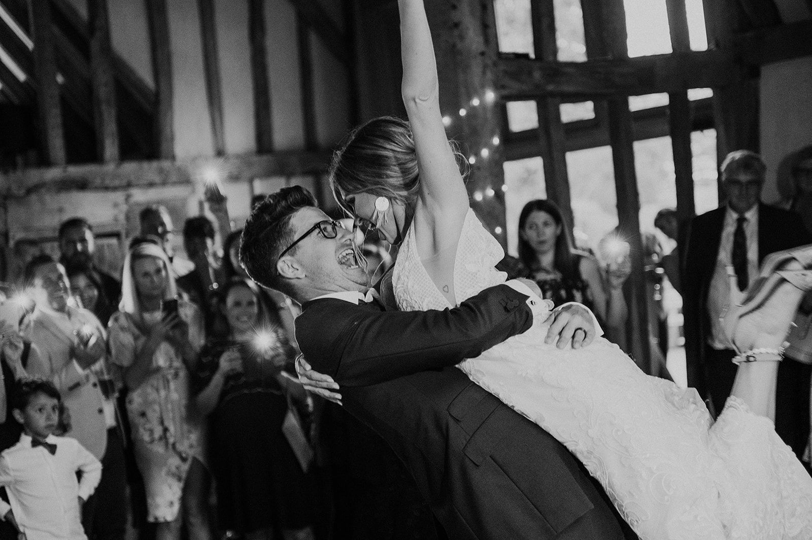 A black and white photo of a bride and groom dancing at their wedding reception.
