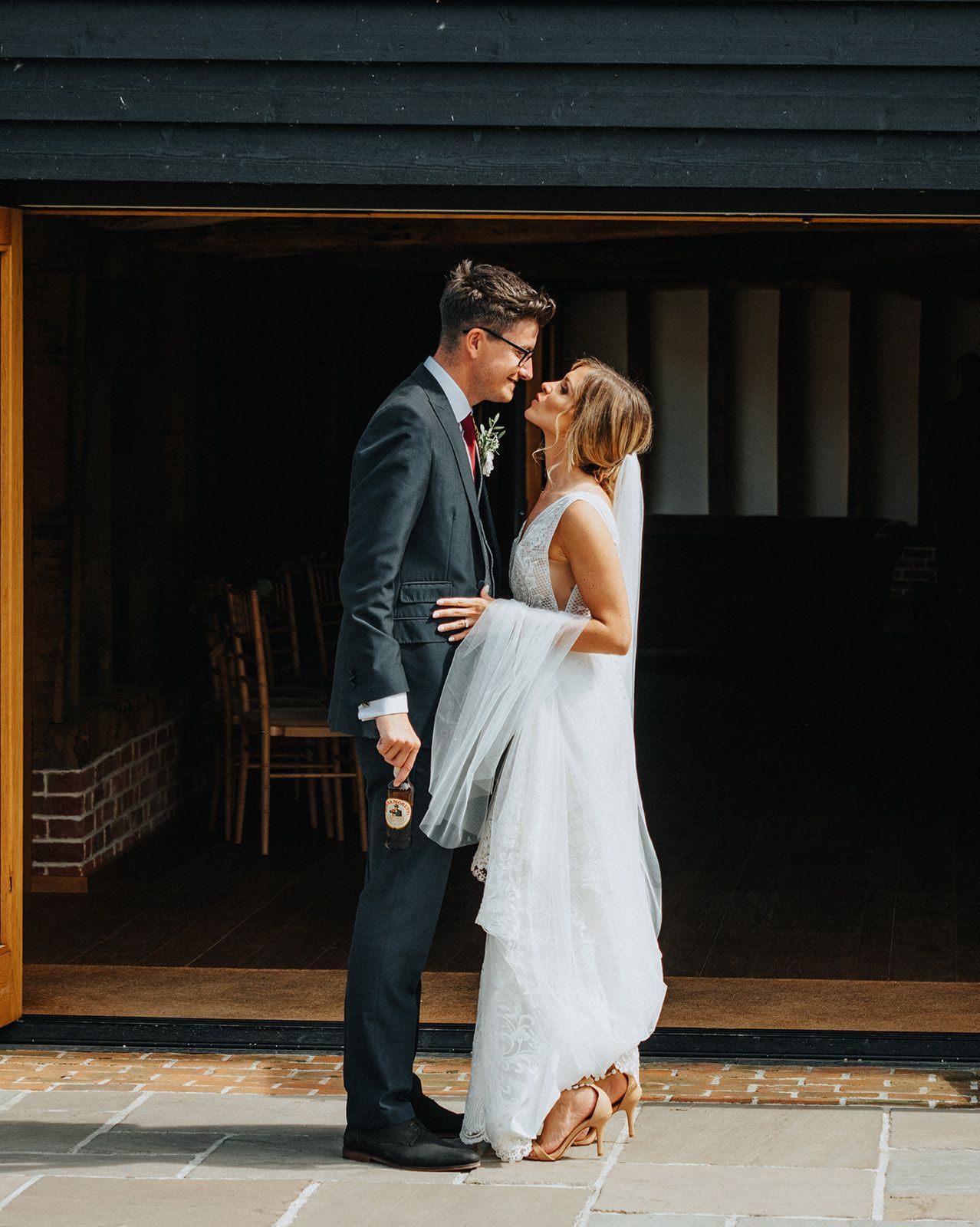 A bride and groom are standing next to each other in front of a building.