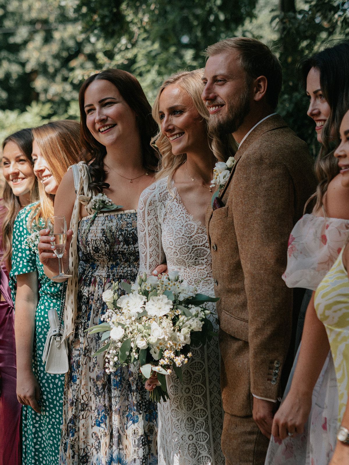 A bride and groom are posing for a picture with their wedding party.