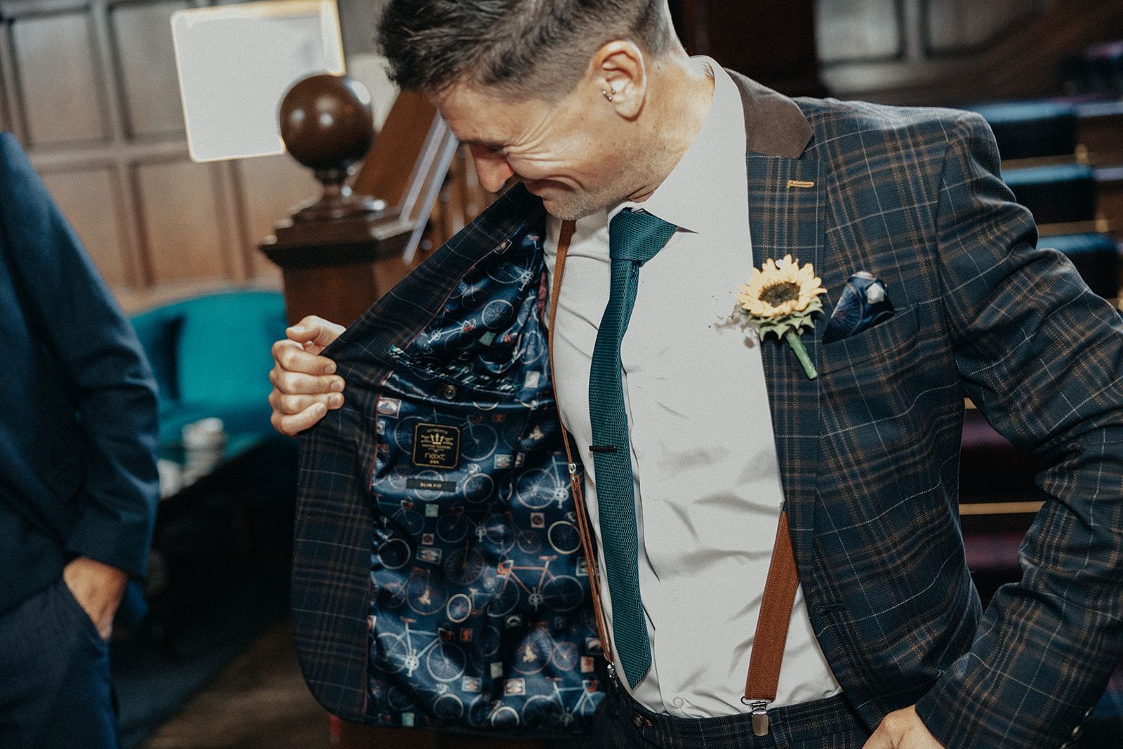 A man in a suit and tie is taking off his jacket.