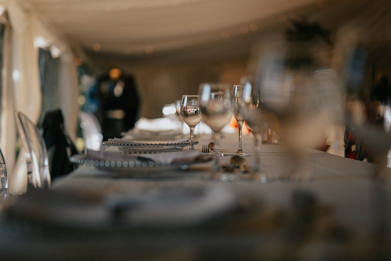 A table with plates and wine glasses on it in a restaurant.