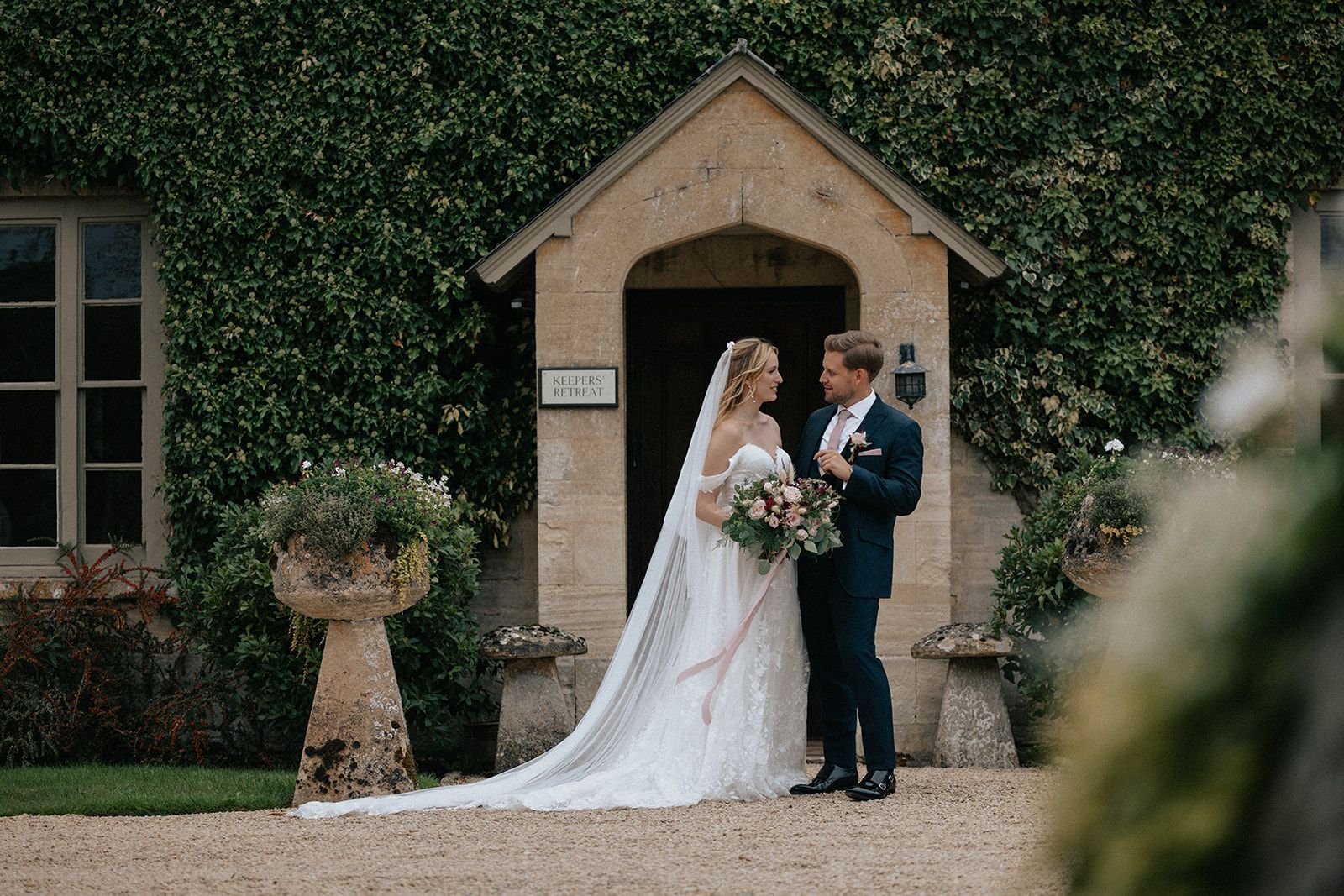A bride and groom are standing in front of a building.