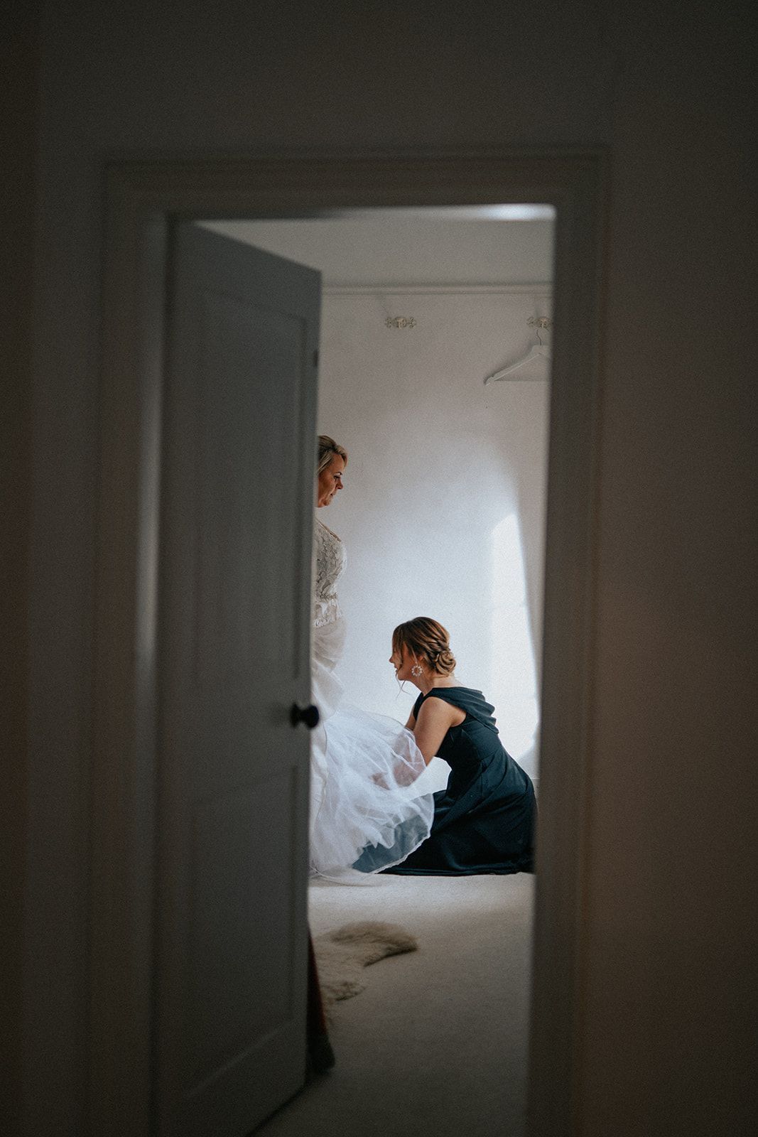 A woman in a wedding dress is kneeling on a bed.