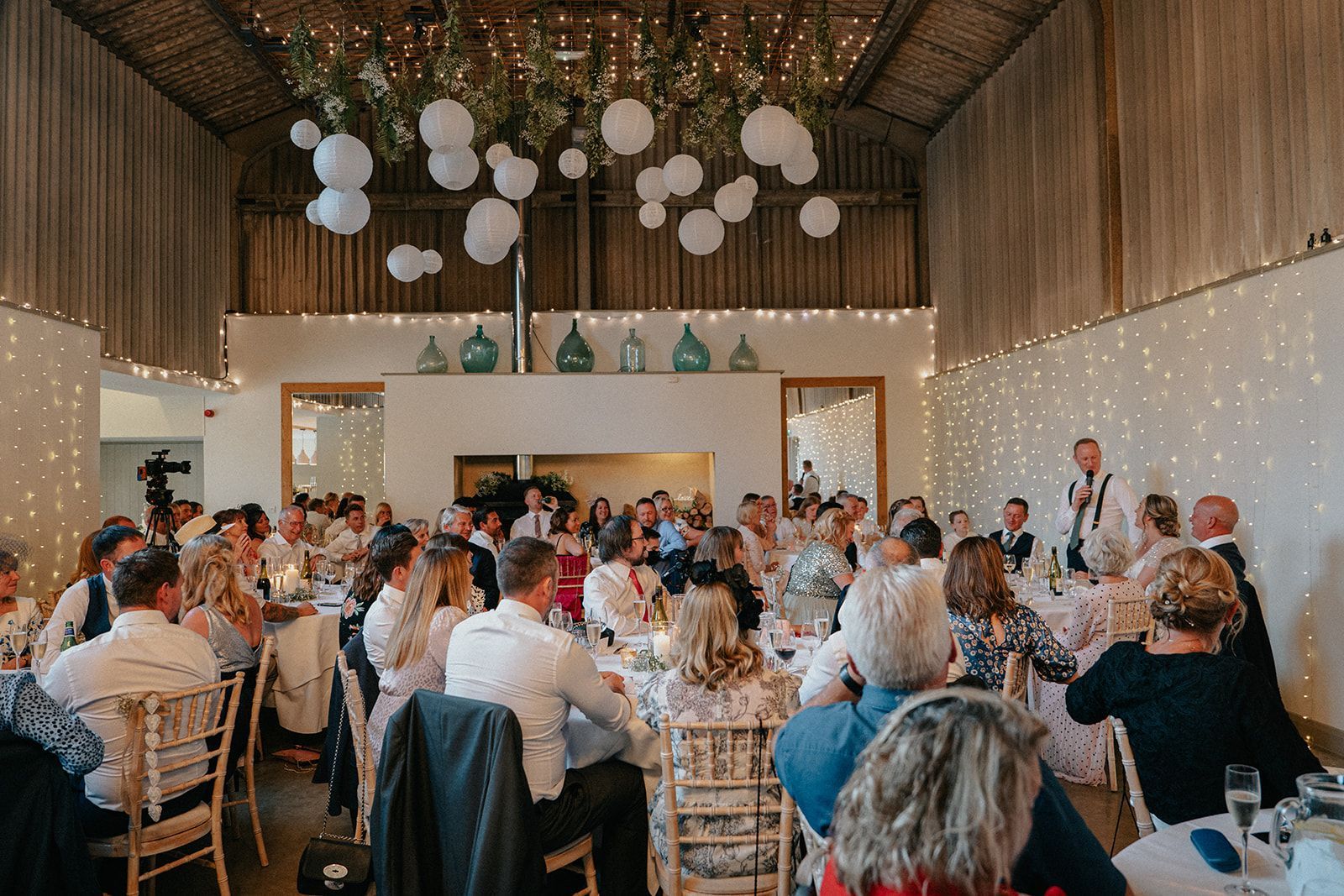 A large group of people are sitting at tables at a wedding reception.