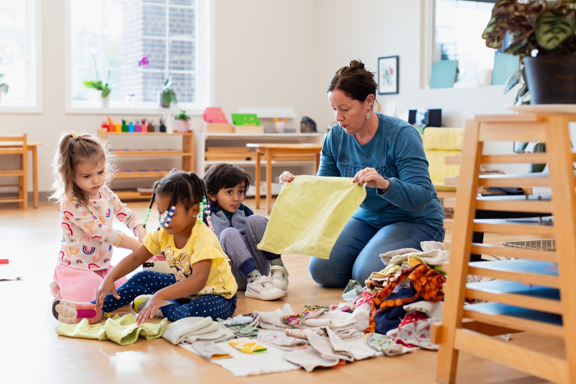 Montessori guide and children folding napkins