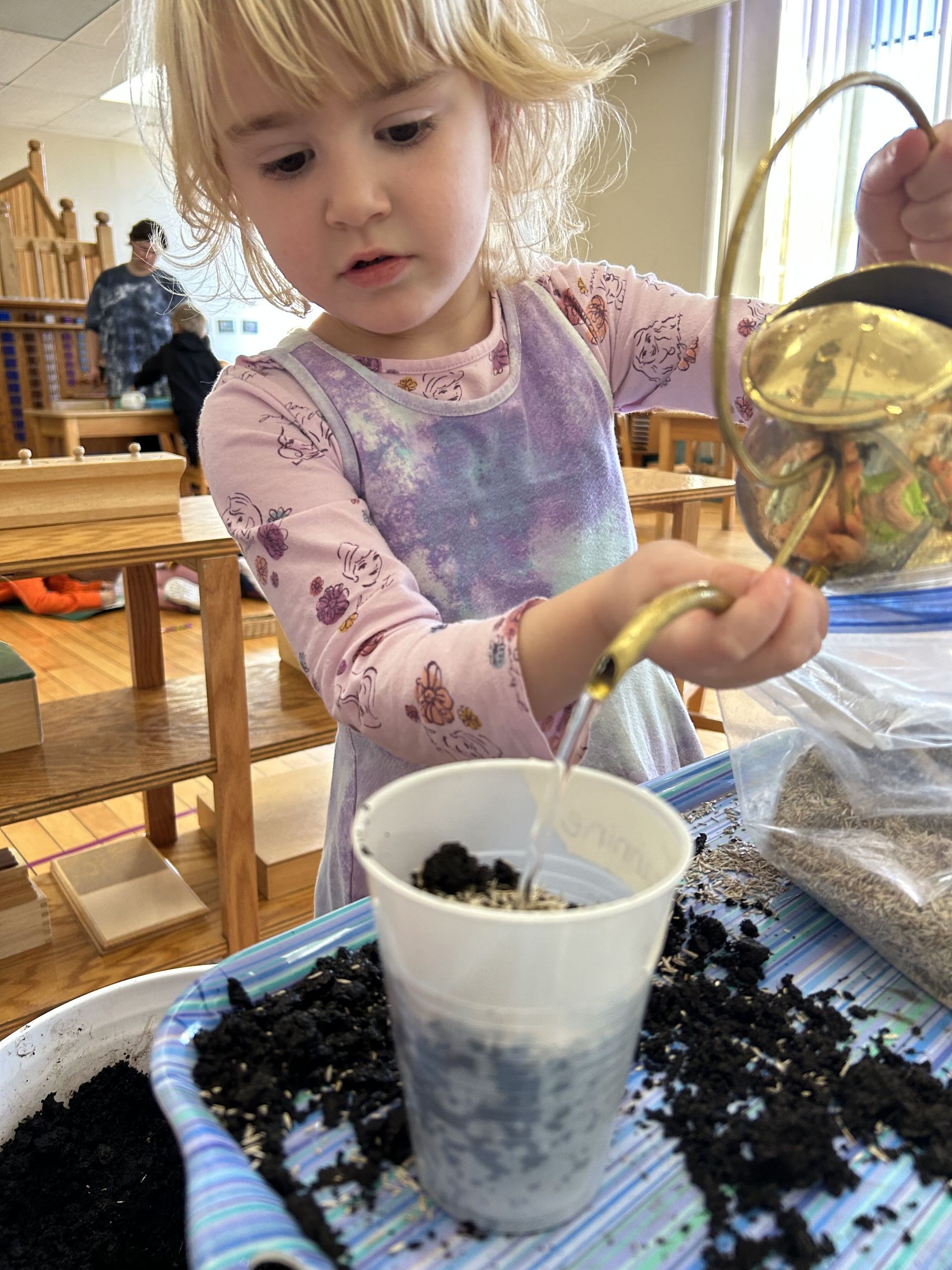 montessori child watering the soil