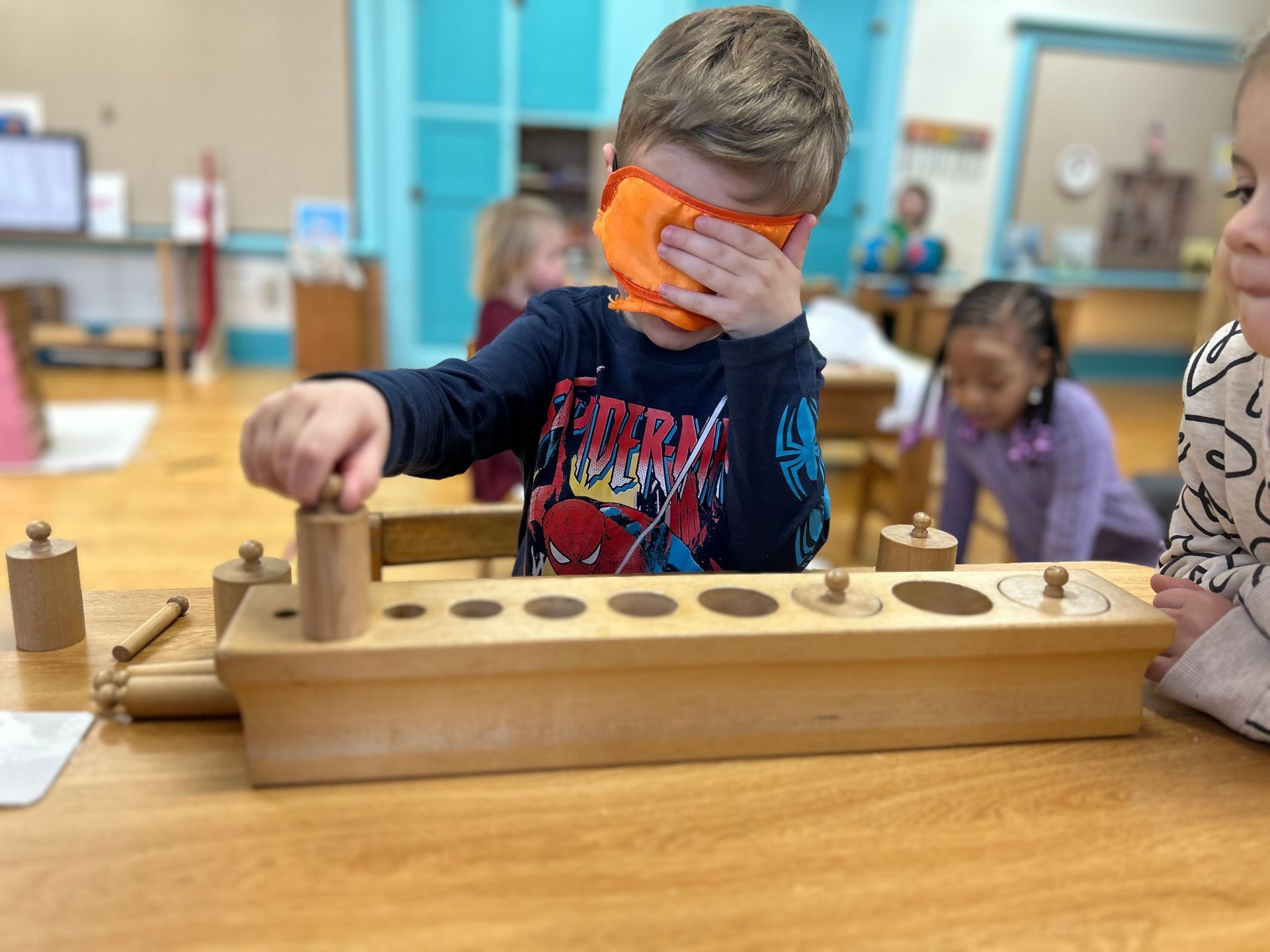 Children working with the Montessori knobbed cylinders