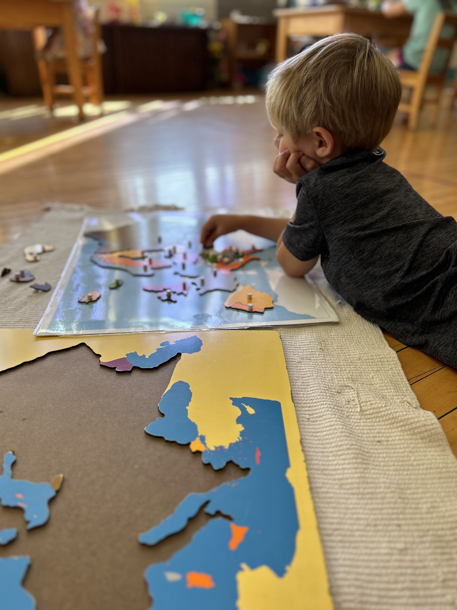 Montessori child working with a map puzzle