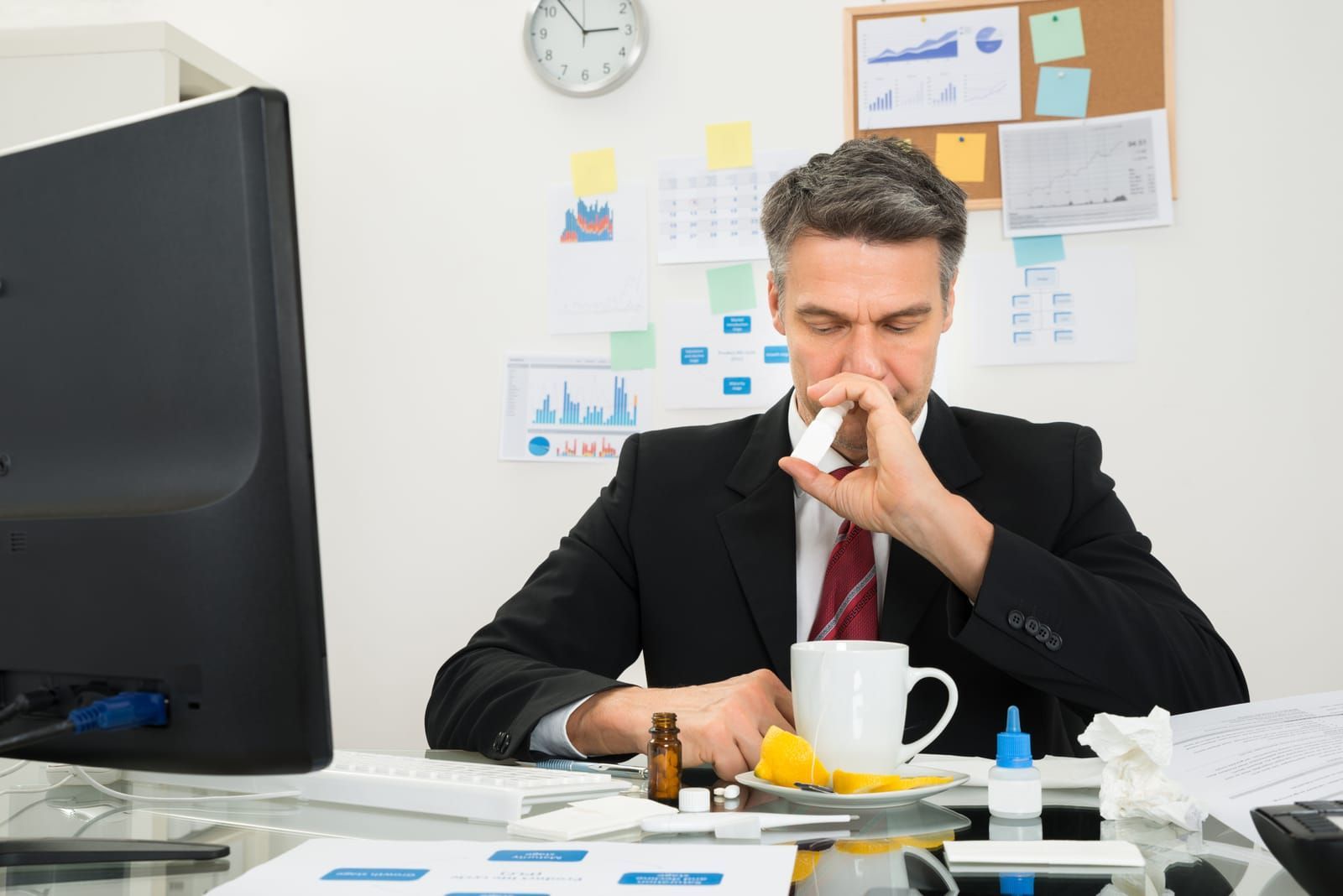 Man using nasal spray to relieve dry nasal passages.