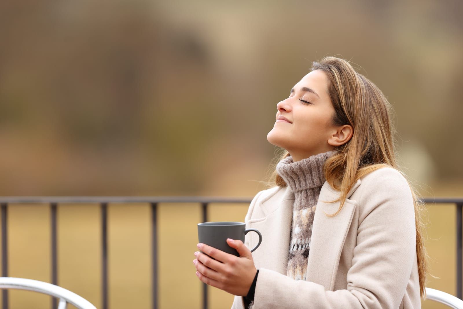 Woman enjoying her coffee after a restful night's sleep, free from the discomfort of a dry nose