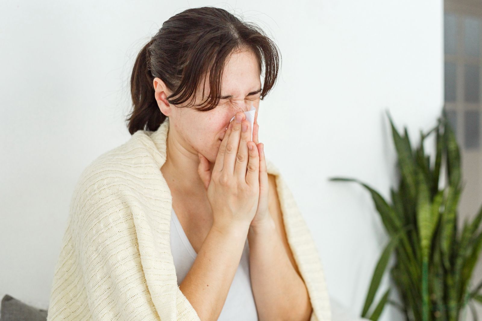 Woman blowing her dry, stuffy nose