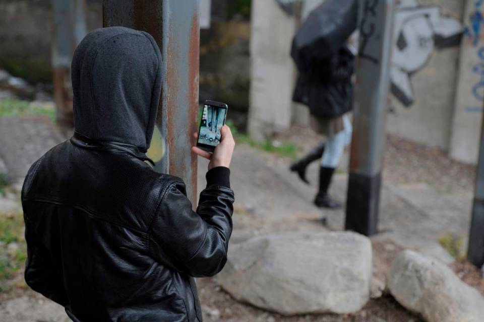 stalker che fa foto ad una persona