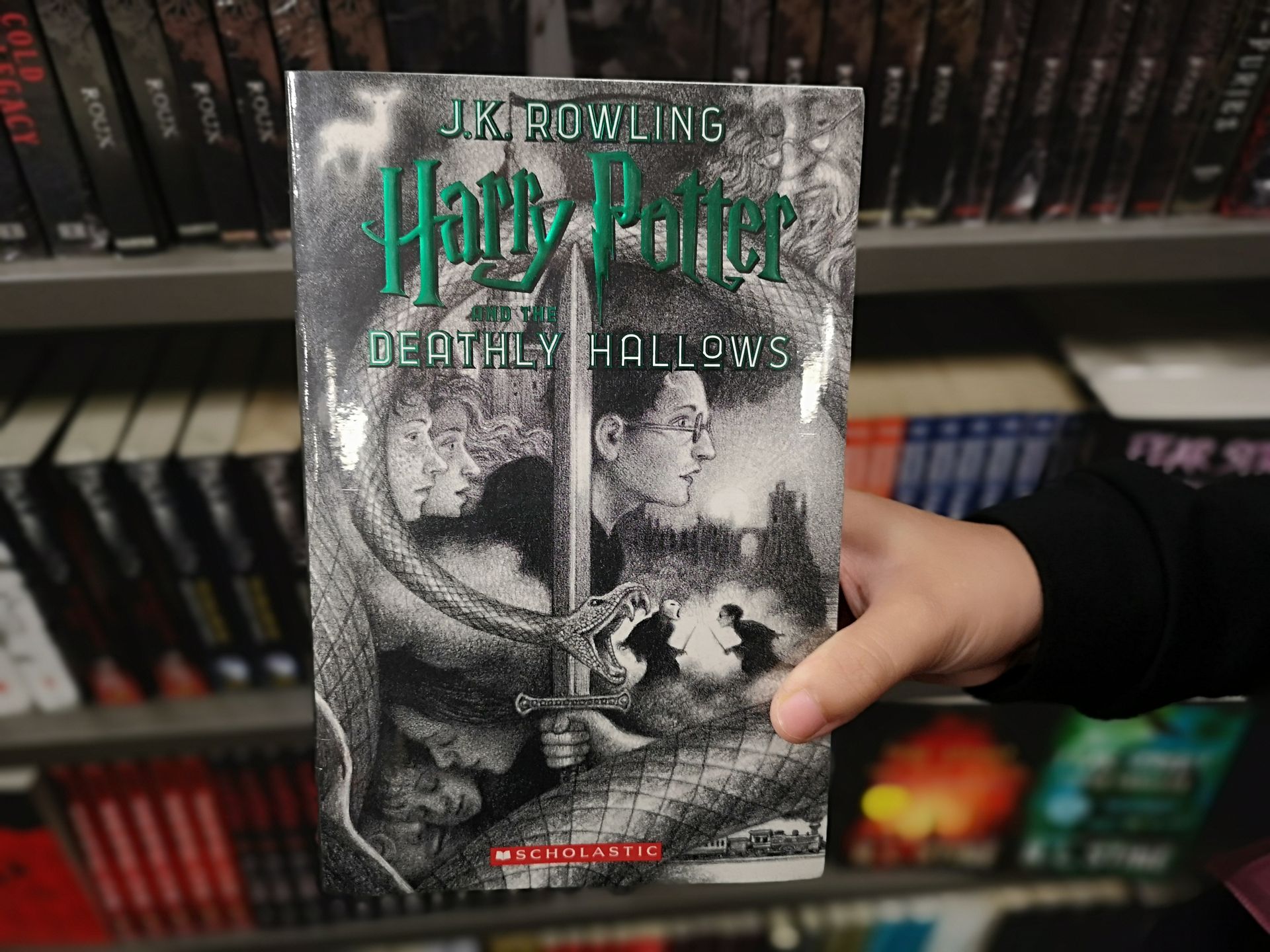 Hand holding a Harry Potter DVD case in front of a store shelf