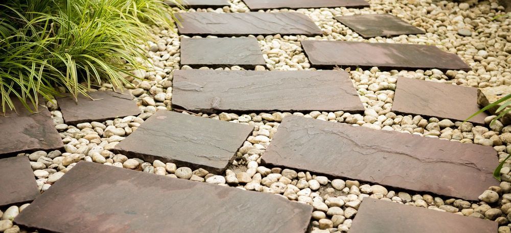 Stone stepping path through pebbles beside green plants