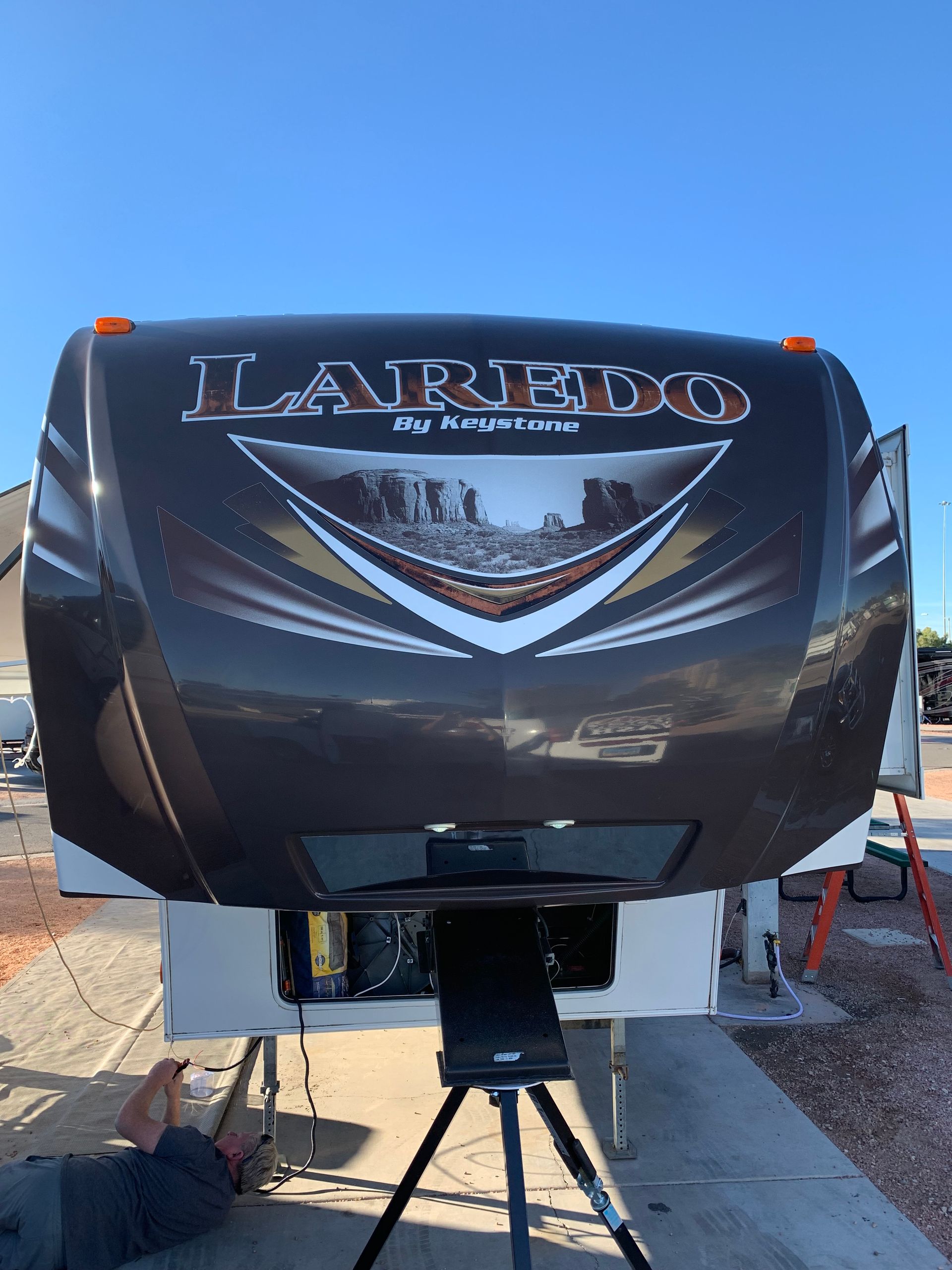 A man is working on the front of a rv.
