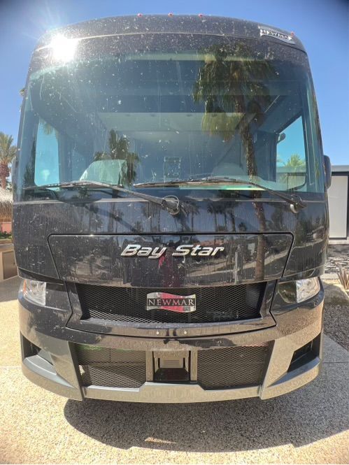 A black bay star rv is parked on the side of the road.
