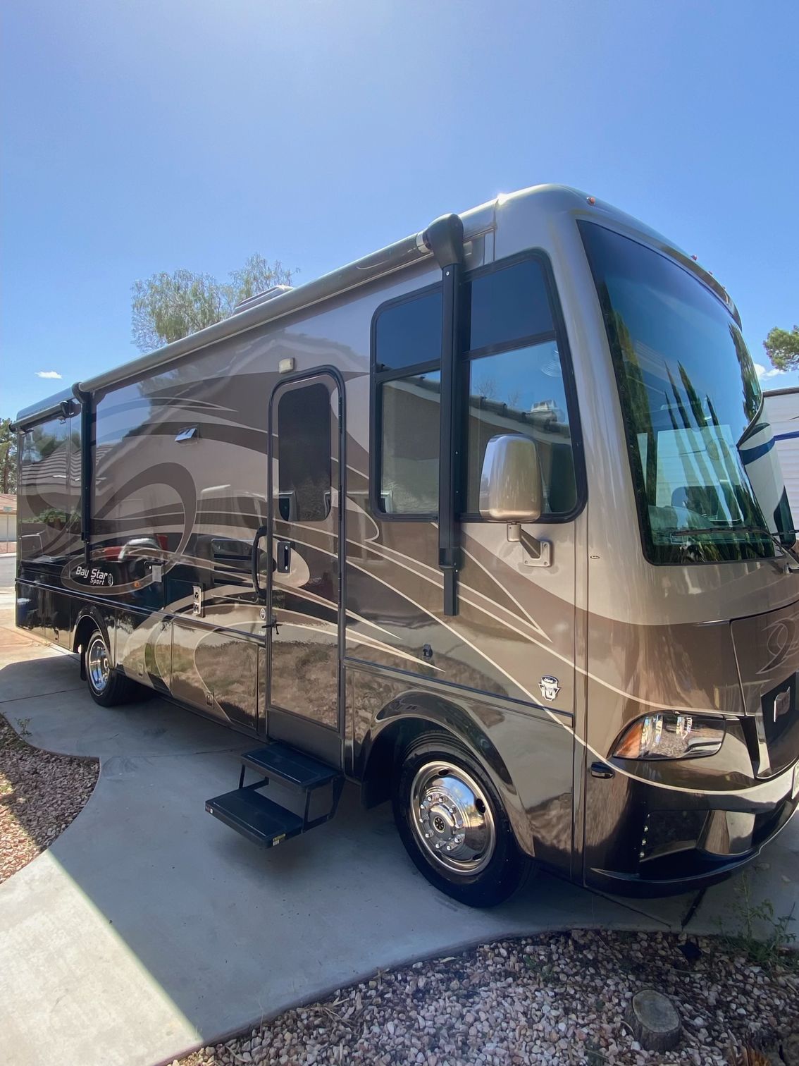 A large rv is parked on the side of the road.