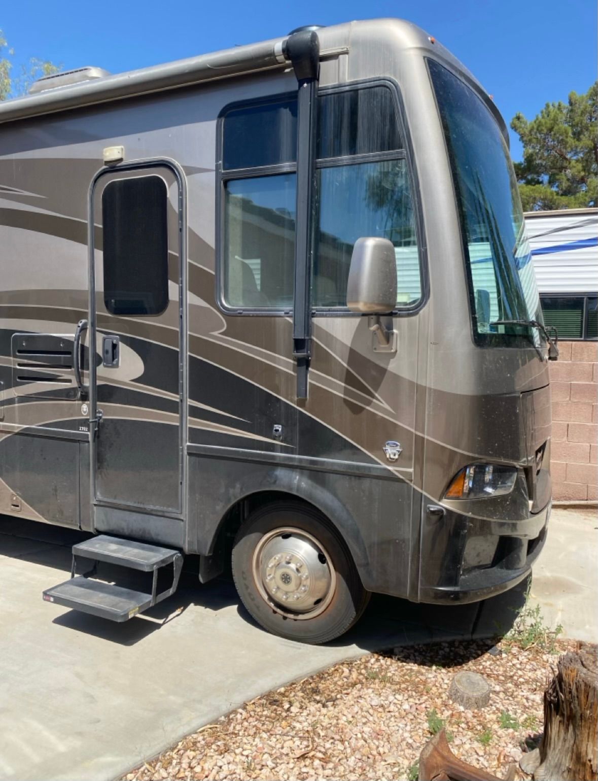 A large rv is parked on the side of the road.