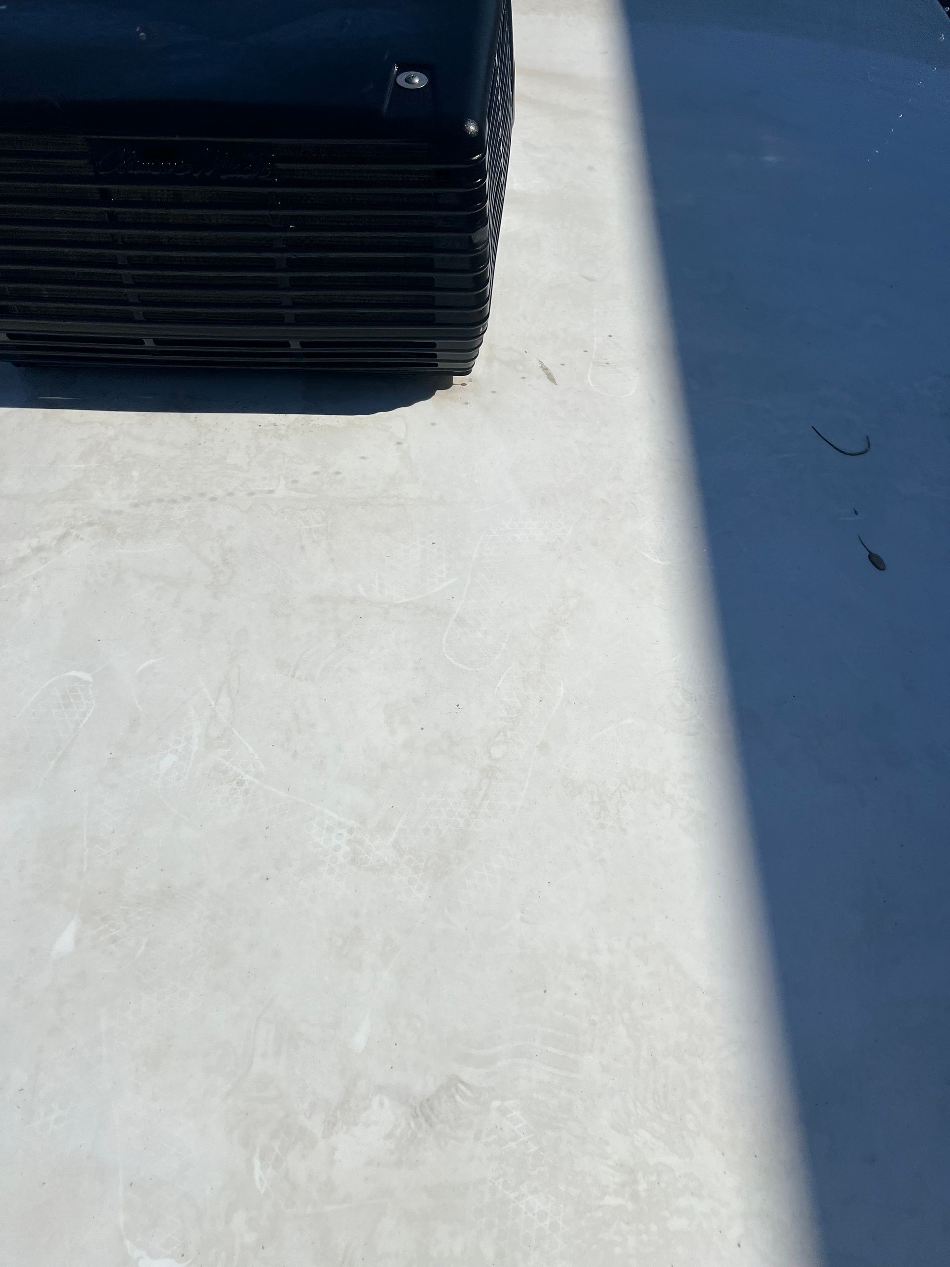 A shadow of a car is cast on a concrete surface.