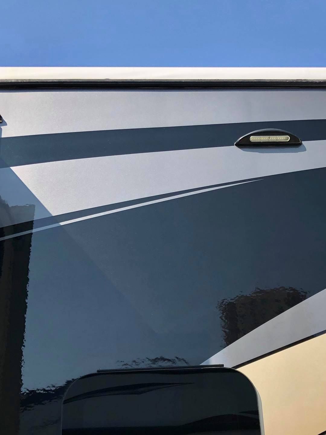 A close up of a car window with a blue sky in the background.