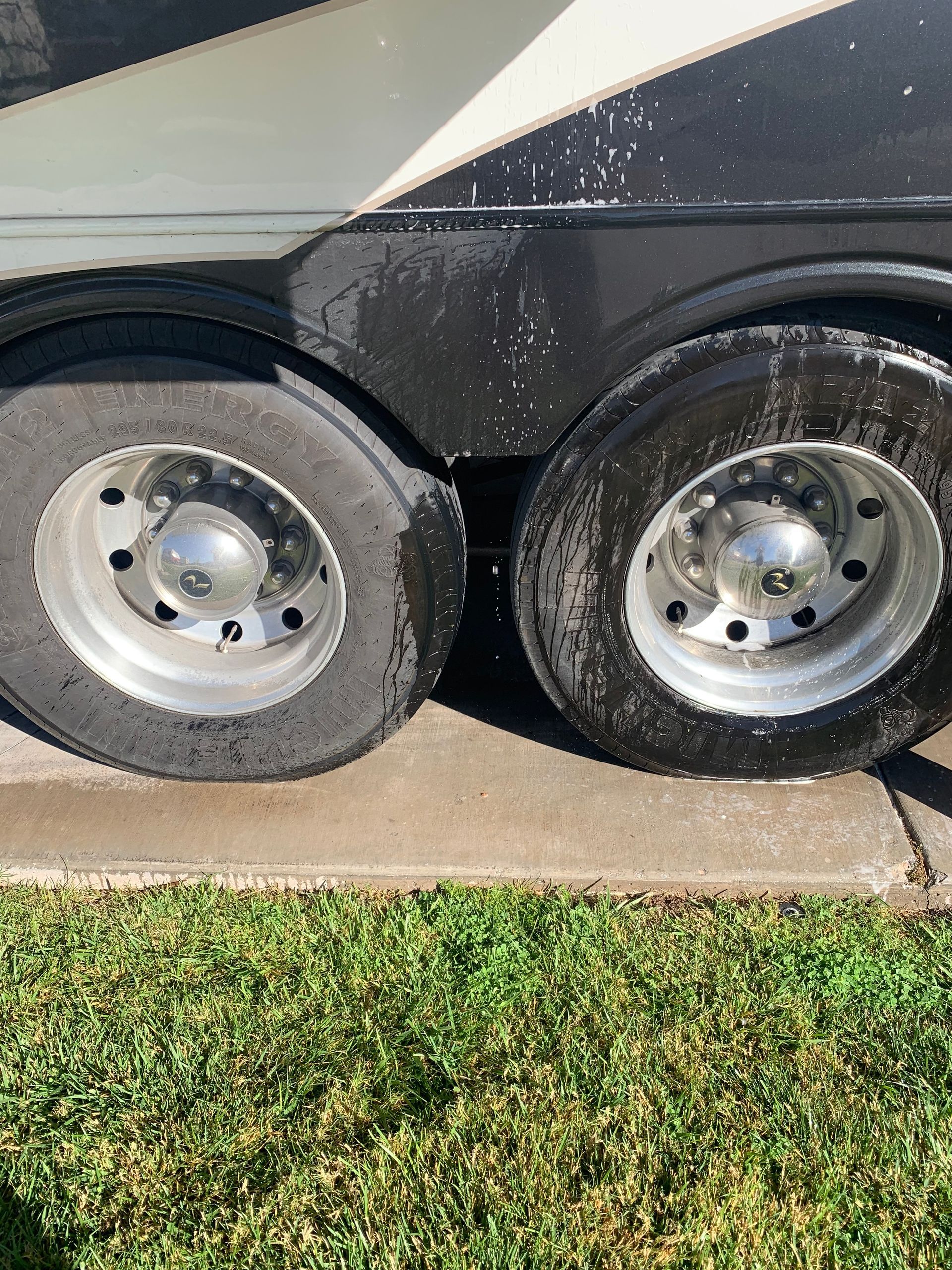 A close up of a trailer 's tires on a sidewalk