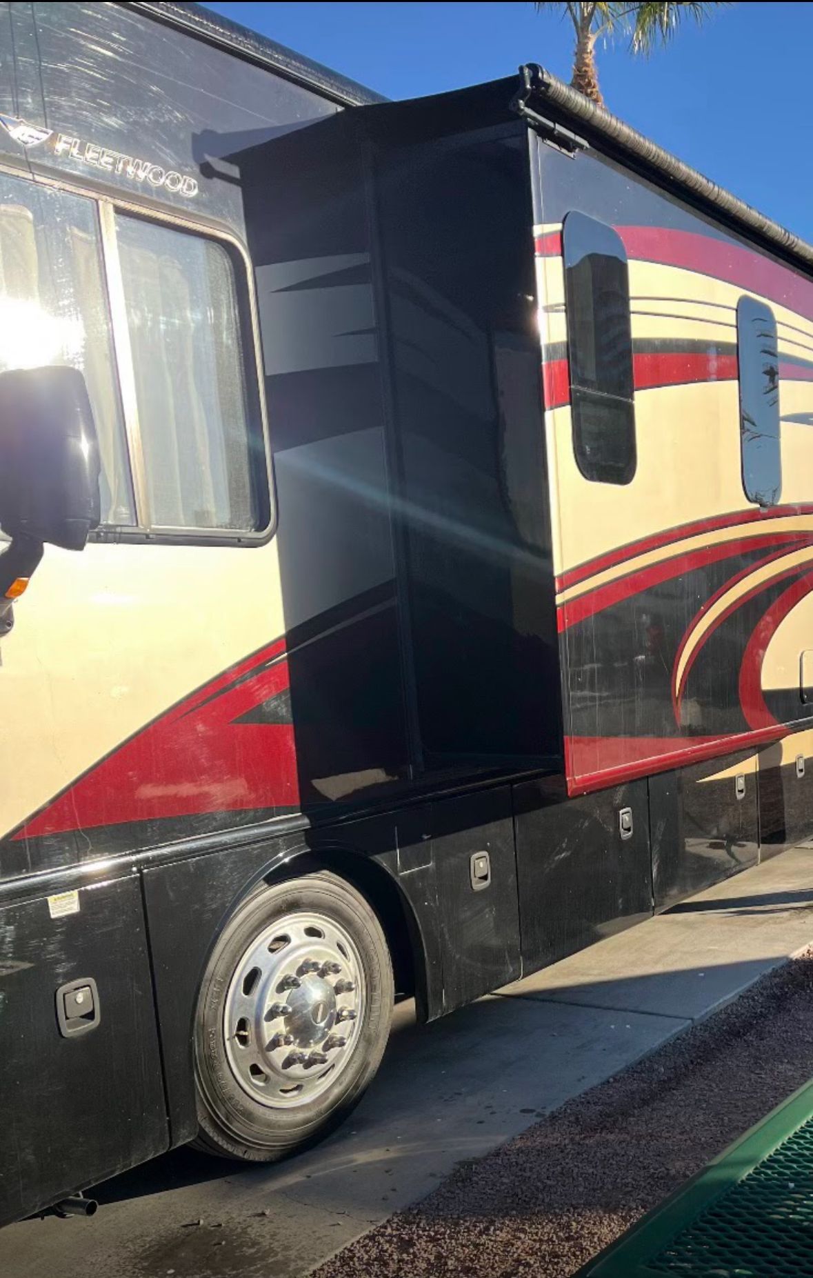 A large rv is parked on the side of the road.
