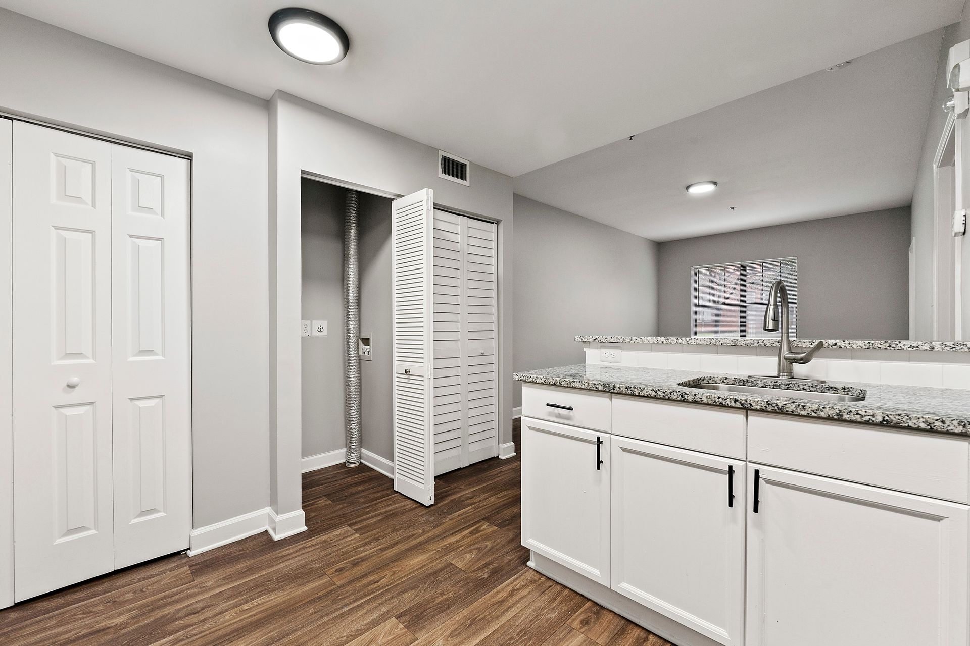Bright modern bathroom with white vanity, double sinks, tiled floor, and open closet area