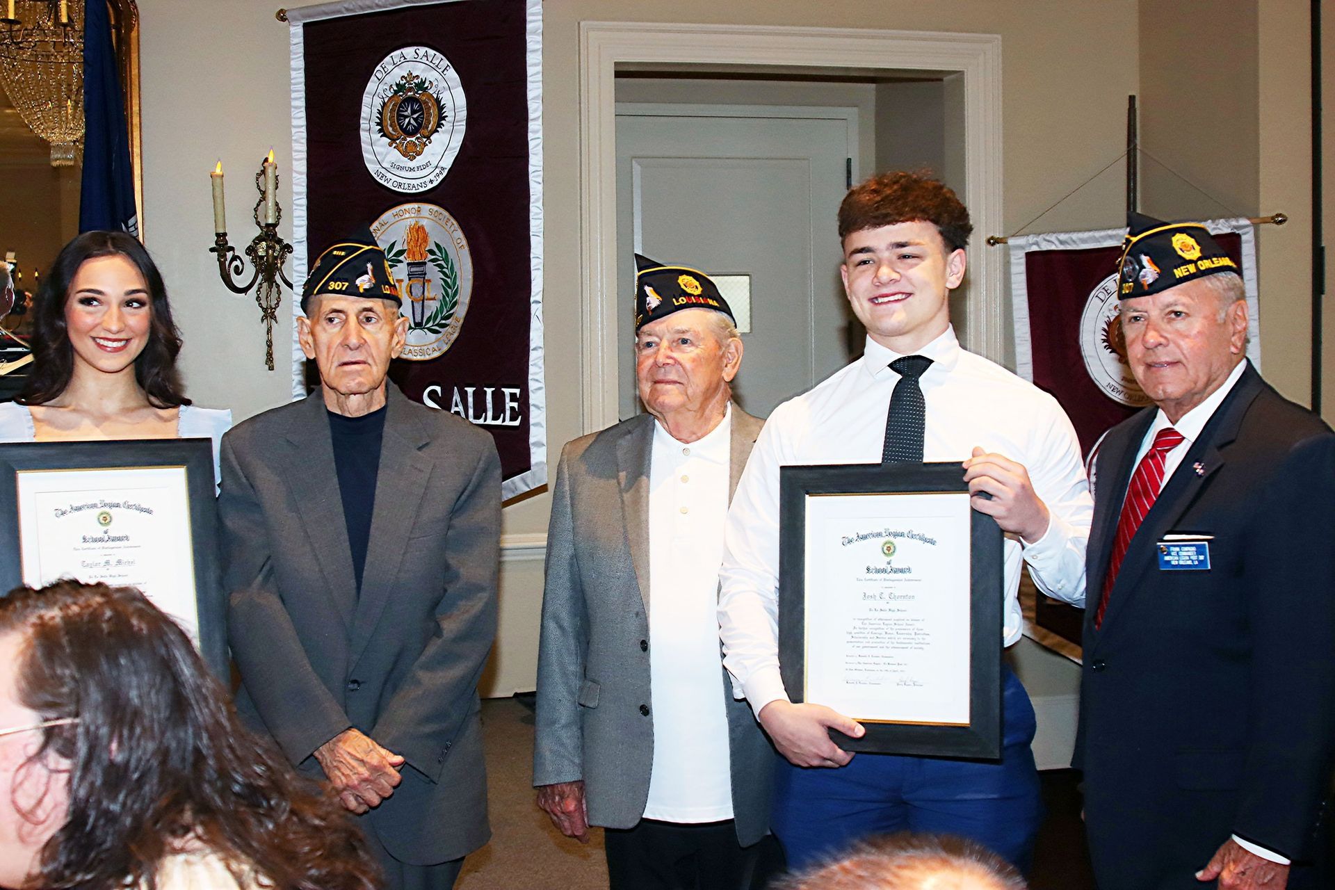 Award recipients posing with certificates at an indoor ceremony