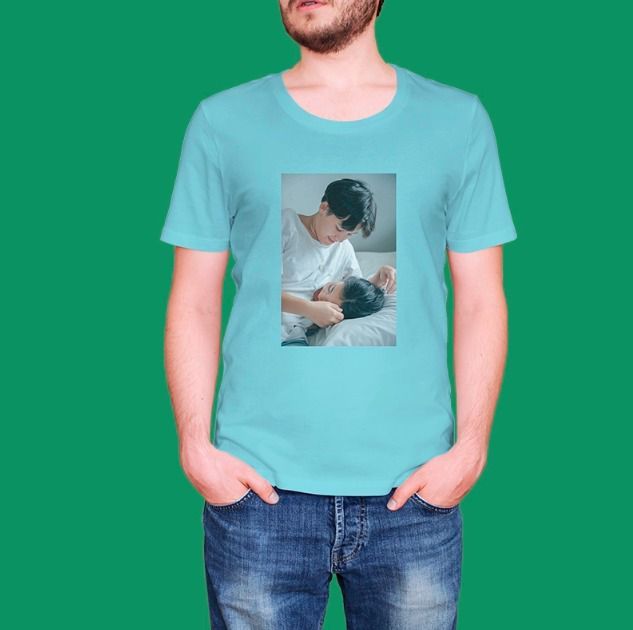 Un hombre que lleva una camiseta azul claro con la foto de dos personas tumbadas en una cama.