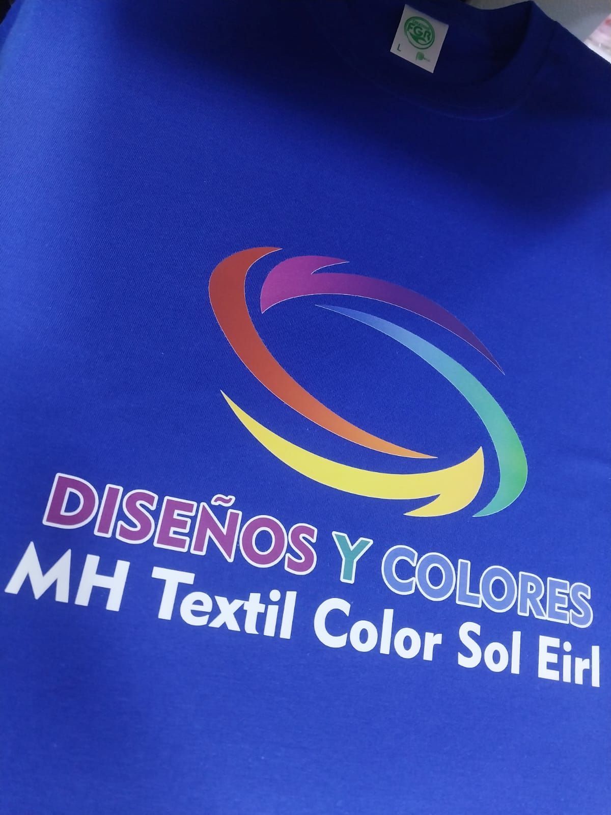 Una camiseta azul rey con un logotipo de espiral colorido sobre el texto 