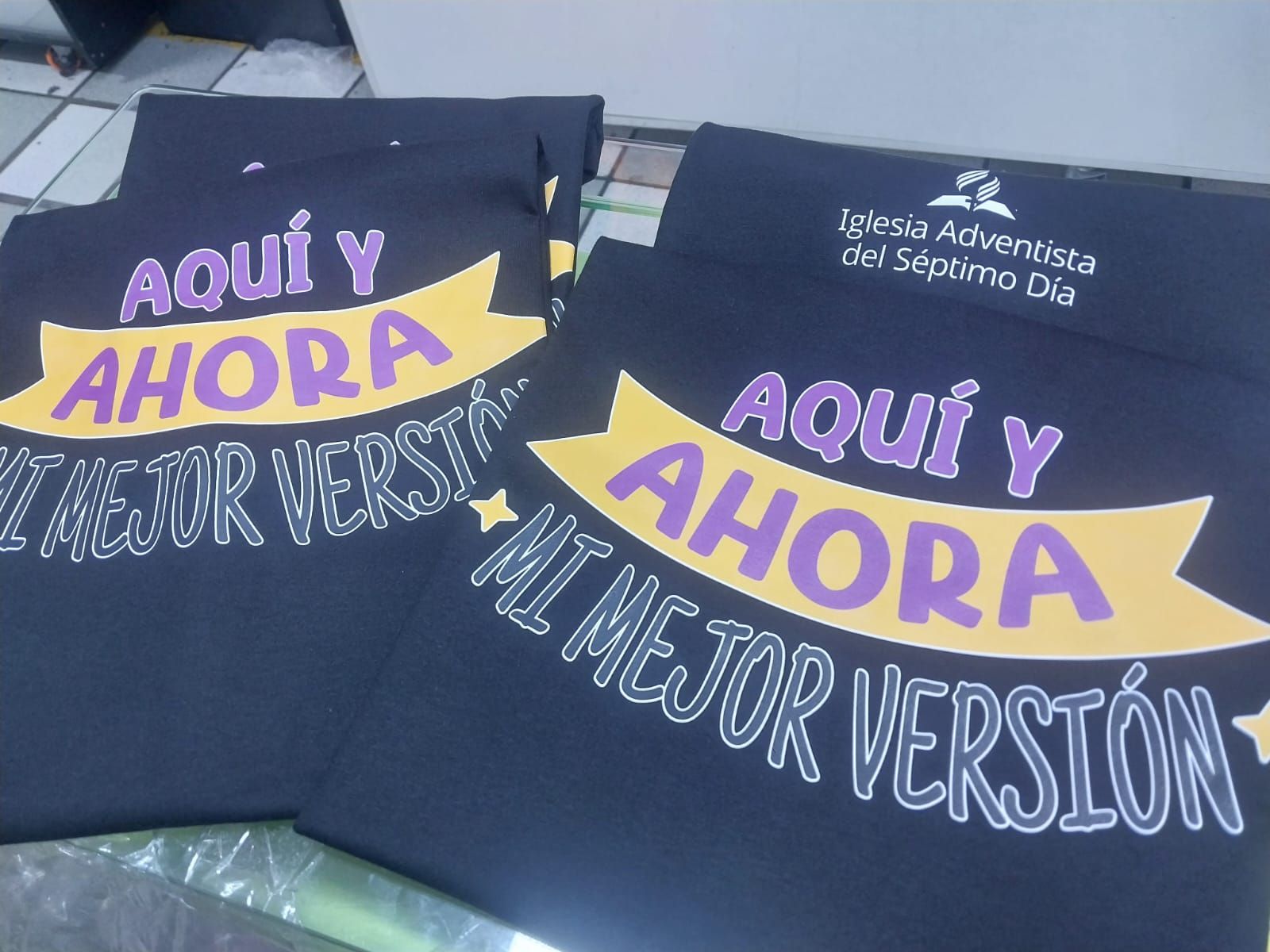 Dark blue t-shirts featuring the yellow banner text 