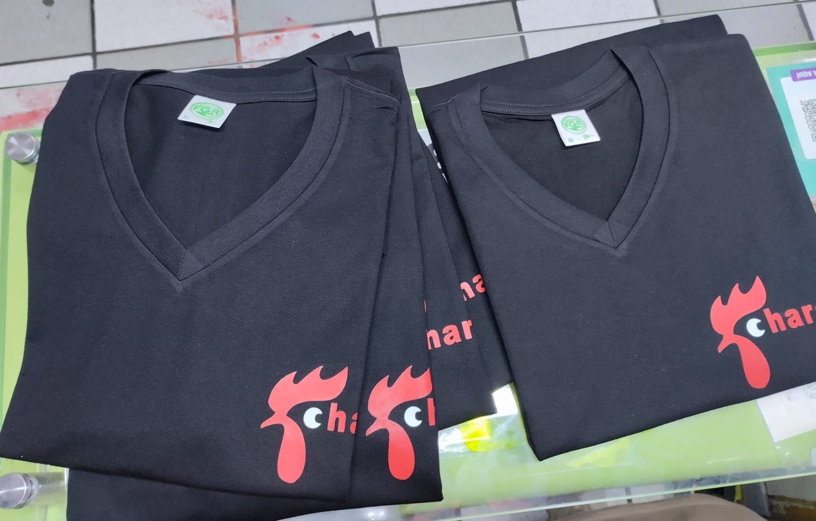 Una pila de camisetas negras con cuello en V